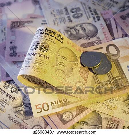 Stock Photo - High angle view of Indian banknotes and coins with a fifty Euro banknote. Fotosearch