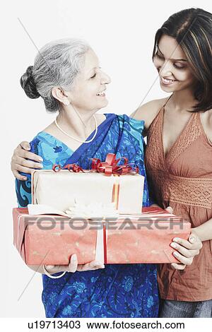 Close-up of a girl giving a gift to her grandmother View Large Photo Image Stock Image - Close-up of a girl giving a gift to her grandmother. Fotosearch