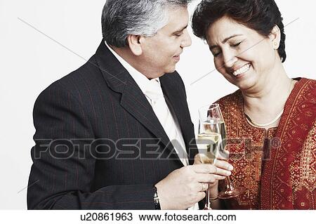 Close-up of a mature couple toasting with champagne flutes View Large Photo Image Stock Image - Close-up of a mature couple toasting with champagne flutes. Fotosearch