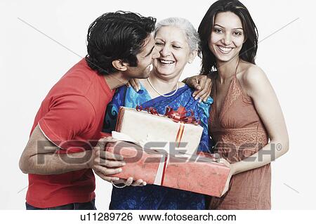 Mature woman holding gifts with her two grandchildren View Large Photo Image Stock Photograph - Mature woman holding gifts with her two grandchildren. Fotosearch