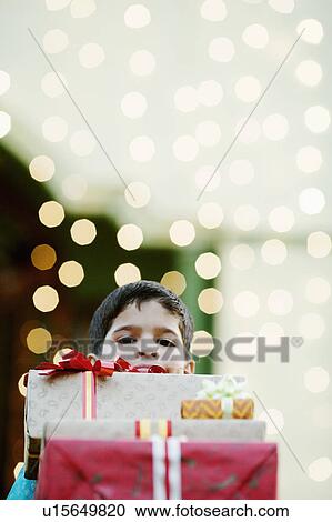 Portrait of a boy behind a stack of gifts View Large Photo Image Stock Image - Portrait of a boy behind a stack of gifts. Fotosearch