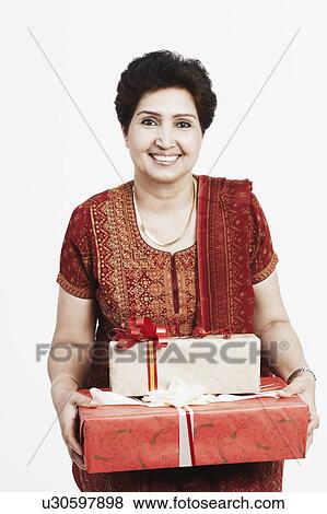 Stock Photo - Portrait of a mature woman holding gifts. Fotosearch