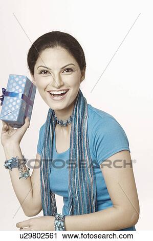 Portrait of a young woman holding a gift View Large Photo Image Stock Image - Portrait of a young woman holding a gift. Fotosearch