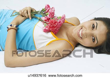 Stock Photograph - Portrait of a young woman holding a bunch of flowers and smiling. Fotosearch