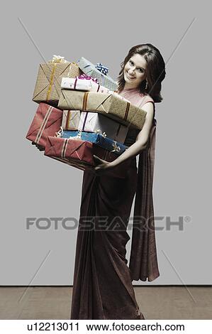Portrait of a young woman holding gifts View Large Photo Image Stock Image - Portrait of a young woman holding gifts. Fotosearch