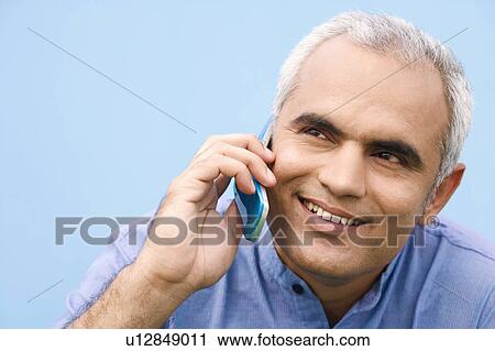 Stock Image - Close-up of a mid adult man talking on a mobile phone. Fotosearch
