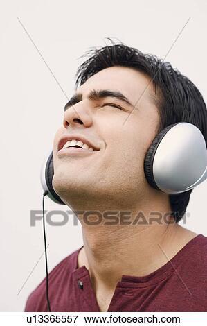 Stock Photo - Close-up of a young man listening to music. Fotosearch