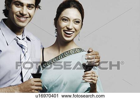 Portrait of a young couple holding wineglasses View Large Photo Image Stock Image - Portrait of a young couple holding wineglasses. Fotosearch