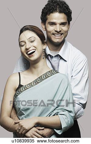 Portrait of a young man embracing a young woman from behind View Large Photo Image Stock Photography - Portrait of a young man embracing a young woman from behind. Fotosearch