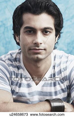 Stock Image - Portrait of a young man wearing a wristband. Fotosearch