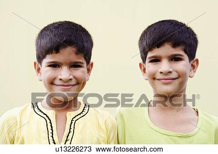 Stock Image - Portrait of twin brothers smiling. Fotosearch