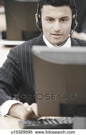 Stock Photography - Close-up of a businessman wearing a headset. Fotosearch