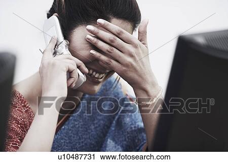 Close-up of a businesswoman with her hand covering her eyes talking on a mobile phone View Large Photo Image Stock Image - Close-up of a businesswoman with her hand covering her eyes talking on a mobile phone. Fotosearch