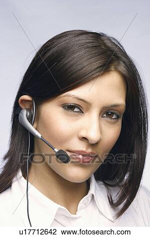 Stock Image - Close-up of a female customer service representative wearing a headset. Fotosearch