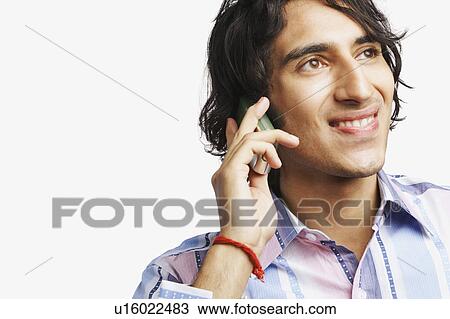 Close-up of a young man talking on a mobile phone View Large Photo Image Stock Image - Close-up of a young man talking on a mobile phone. Fotosearch