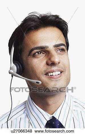 Stock Photo - Close-up of a young man wearing a headset and smiling. Fotosearch