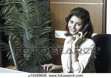 Portrait of a receptionist talking on the telephone View Large Photo Image Stock Photograph - Portrait of a receptionist talking on the telephone. Fotosearch