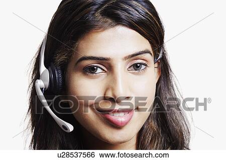 Portrait of a young woman wearing a headset and smiling View Large Photo Image Stock Photograph - Portrait of a young woman wearing a headset and smiling. Fotosearch