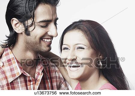 Stock Photograph - Close-up of a young couple embracing each other and laughing. Fotosearch