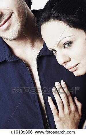 Close-up of a young couple embracing each other View Large Photo Image Stock Photograph - Close-up of a young couple embracing each other. Fotosearch