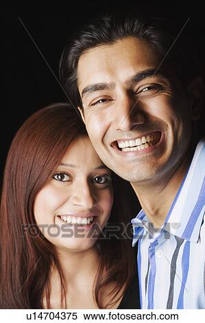 Stock Photography - Close-up of a young couple smiling. Fotosearch