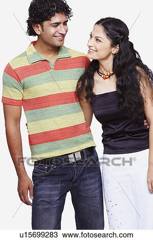 Close-up of a young couple standing with their arms around each other View Large Photo Image Stock Image - Close-up of a young couple standing with their arms around each other. Fotosearch