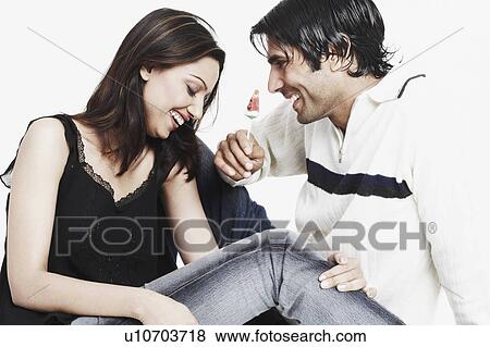Close-up of a young man sitting with a young woman and holding a lollipop View Large Photo Image Stock Photo - Close-up of a young man sitting with a young woman and holding a lollipop. Fotosearch