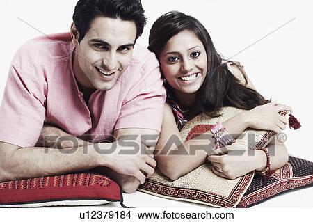 Picture - Portrait of a young couple lying on the floor and smiling. Fotosearch
