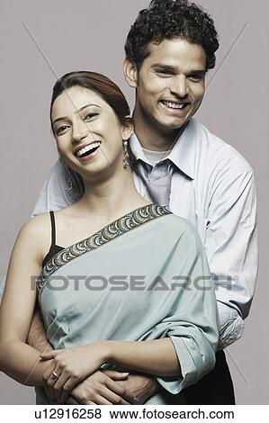 Portrait of a young man embracing a young woman from behind View Large Photo Image Stock Photo - Portrait of a young man embracing a young woman from behind. Fotosearch