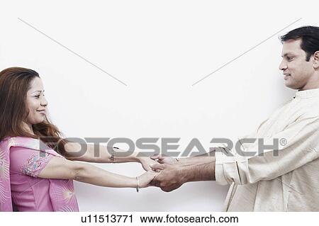 Side profile of a mid adult couple holding hands View Large Photo Image Stock Image - Side profile of a mid adult couple holding hands. Fotosearch