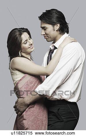 Stock Photography - Side profile of a young couple looking at each other. Fotosearch