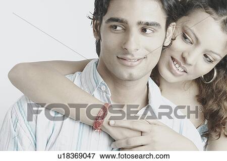 Stock Photo - Young woman hugging a young man. Fotosearch