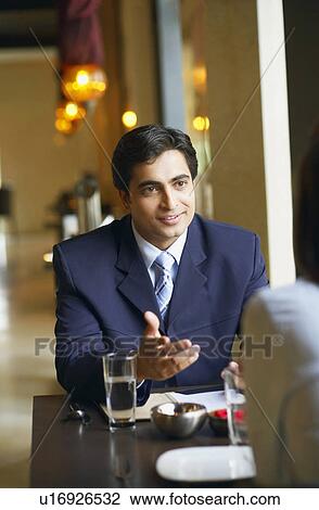 Stock Image - Businessman and a businesswoman sitting in a restaurant. Fotosearch