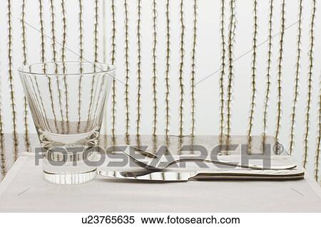 Close-up of a table knife and a spoon with a glass of water View Large Photo Image Stock Photography - Close-up of a table knife and a spoon with a glass of water. Fotosearch