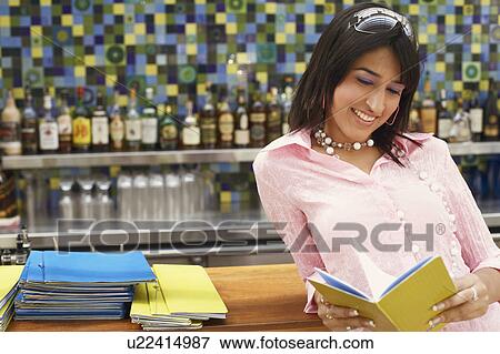 Close-up of a young woman holding a menu View Large Photo Image Stock Photo - Close-up of a young woman holding a menu. Fotosearch