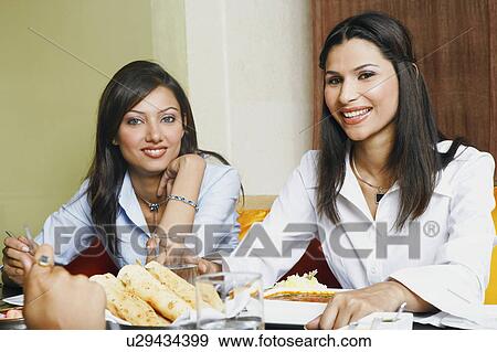 Stock Photo - Close-up of two young women eating. Fotosearch