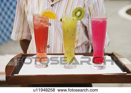 Mid section view of a waiter holding a tray of drinks View Large Photo Image Stock Photo - Mid section view of a waiter holding a tray of drinks. Fotosearch