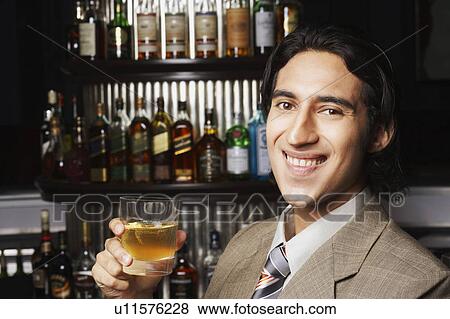 Portrait of a businessman holding a glass of whiskey View Large Photo Image Stock Photo - Portrait of a businessman holding a glass of whiskey. Fotosearch