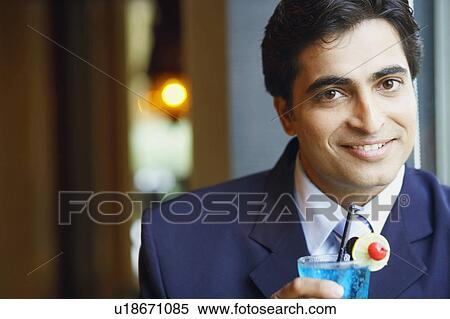 Portrait of a businessman holding a glass of cocktail View Large Photo Image Stock Photography - Portrait of a businessman holding a glass of cocktail. Fotosearch