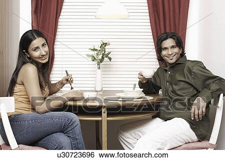 Portrait of a young couple eating in a restaurant View Large Photo Image Stock Photograph - Portrait of a young couple eating in a restaurant. Fotosearch