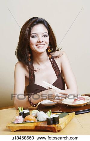 Portrait of a young woman sitting at the dining table and smiling View Large Photo Image Stock Image - Portrait of a young woman sitting at the dining table and smiling. Fotosearch