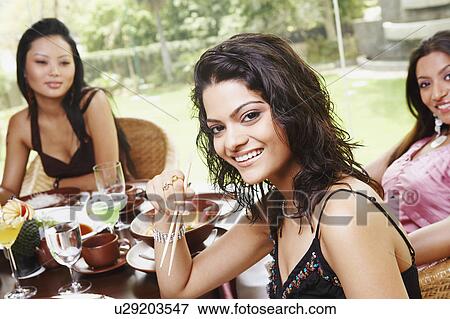 Three young women dining in a restaurant View Large Photo Image Stock Photo - Three young women dining in a restaurant. Fotosearch