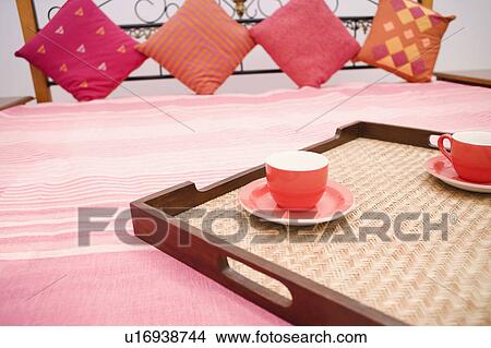 Two tea cups in a tray on the bed View Large Photo Image Picture - Two tea cups in a tray on the bed. Fotosearch