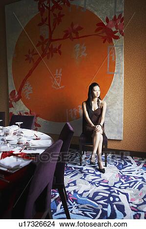 Young woman sitting in a restaurant with her legs crossed at the knee View Large Photo Image Picture - Young woman sitting in a restaurant with her legs crossed at the knee. Fotosearch