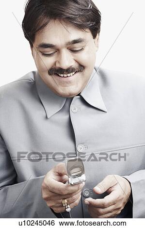 Stock Photograph - Close-up of a businessman holding a mobile phone. Fotosearch
