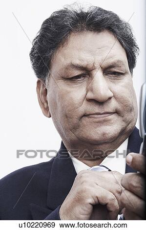 Stock Photo - Close-up of a businessman operating a mobile phone. Fotosearch