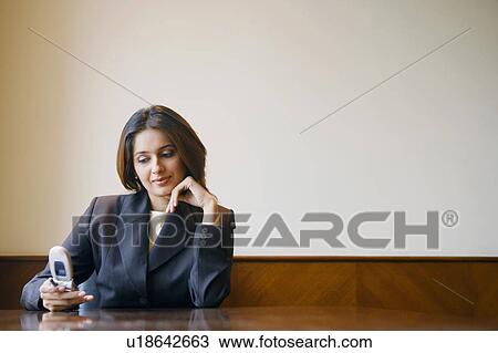 Close-up of a businesswoman using a mobile phone in a conference room View Large Photo Image Stock Image - Close-up of a businesswoman using a mobile phone in a conference room. Fotosearch