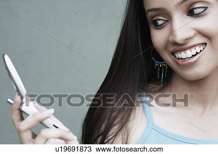 Stock Image - Close-up of a teenage girl holding a mobile phone. Fotosearch