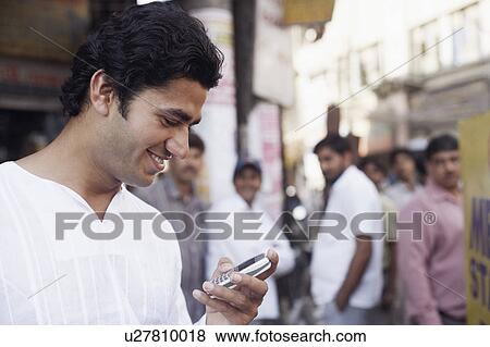 Stock Photo - Close-up of a young man holding a mobile phone. Fotosearch