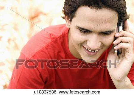 Stock Photograph - Close-up of a young man talking on a mobile phone. Fotosearch